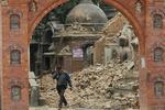 En mand græder, mens han går gennem murbrokkerne i Kathmandu. 