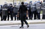 Uro. En demonstrant foran politikæder i Baltimore efter begravelse af sort mand, der døde efter skader pådraget, mens han var i politiets varetægt. 