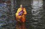 Oversvømmet. En thailandsk munk vader gennem vandet efter en oversvømmelse nær Bangkok i november 2011. En ny rapport viser, at Asien er den verdensdel, der er hårdest ramt af naturkatastrofer. 
