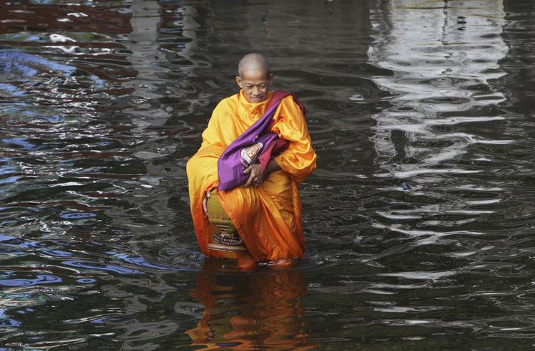 Oversvømmet. En thailandsk munk vader gennem vandet efter en oversvømmelse nær Bangkok i november 2011. En ny rapport viser, at Asien er den verdensdel, der er hårdest ramt af naturkatastrofer. 