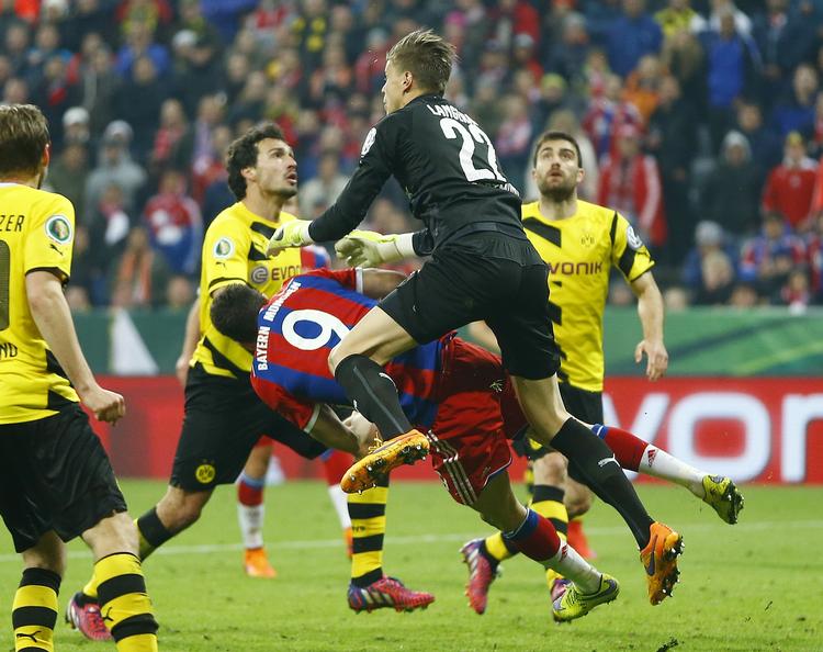 skadet. Bayerns Robert Lewandowski (nummer 9) får en hjernerystelse og brækker kindbenet under et sammenstød med Dortmunds målmand, Mitchell Langerak (th). 