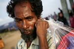 Nødstedt. En flygtning fra Rohingya  -folket bærer sine ejendele i en pose, efter at det er lykkedes ham sammen med andre migranter at komme i land og få ophold i en midlertidig lejr i Indonesien. 
