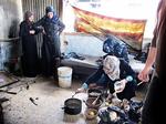 Kogekunst. Kvinderne i familien Sabeh er ved at forberede dagens varme middagsmåltid i det rum, de har indrettet som køkken. 34-årige Amira (tv.) er med god grund bange for, at hende børn skal falde igennem et af husets mange huller. 