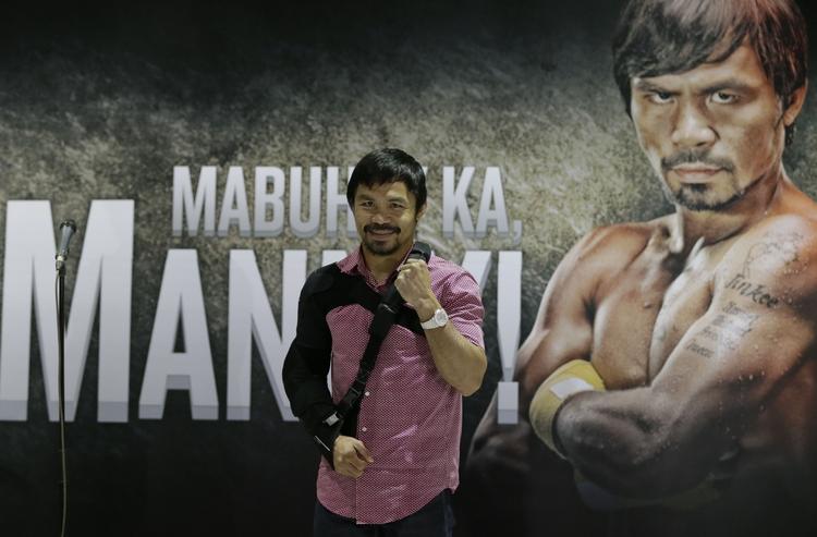 skadet. Manny Pacquiao havde armen i en slynge, da han mødte pressen efter nederlaget til Floyd Mayweather. 