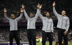 diskvalificeret. Den amerikanske kvartet med Trell Kimmons, Justin Gatling Tyson Gay og Ryan Bailey fejrer deres sølvmedaljer i London - medaljer de nu skal aflevere. 