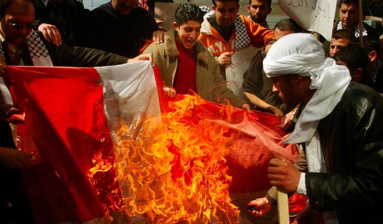 Vrede. Muslimske mænd brænder det danske flag i kølvandet på, at Jyllands-Posten bragte karikaturtegninger af profeten Mohammed i 2005. 