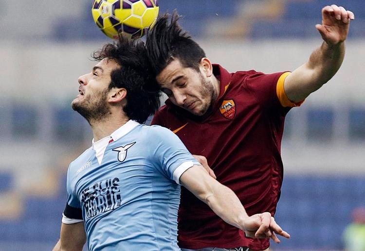 Nærkamp. Lazios Marco Parolo (tv.) i en duel med Romas Kostas Manolas. Billedet er taget, da de to klubber mødtes midt i januar, hvilket er årsagen til, at alle Laziospillerne bar en støtteerklæring til det terrorramte franske magasin Charlie Hebdo på trøjerne. Foto: Gregorio Borgia, AP 