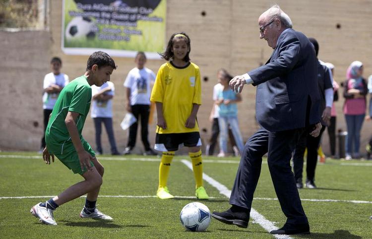 Fredskamp. Fifa-præsident Sepp Blatter er med egne ord på en fredsmission for at løse spændingen mellem det israelske og det palæstinensiske fodboldforbund. Her spiller han bold med nogle drenge i nærheden af Ramallah. Foto: Majdi Mohammed/AP 