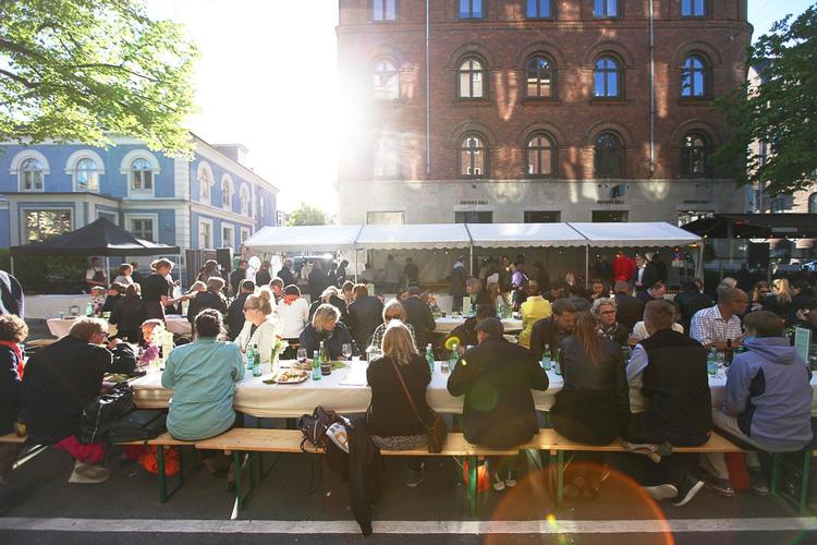 Hygge. Gaden bliver spærret af, så folk kan sidde på langborde og spise middag. 