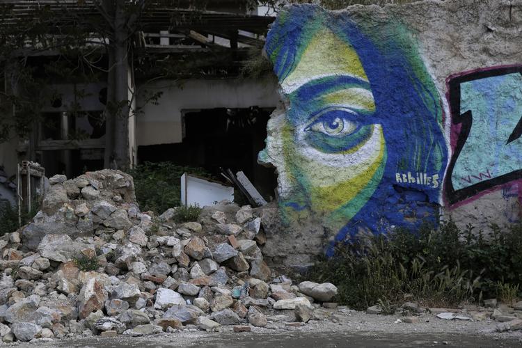 sammenbrudt. Den græske gadekunstner Achilles har lavet denne graffiti på muren til et forladt hus i  Athen. 
