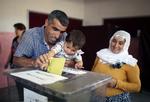 Afstemning. En far får hjælp til at stemme i Diyarbakir i det sydøstlige Tyrkiet, hvor det kurdiske parti HDP har fået omkring 78 procent af stemmerne. 