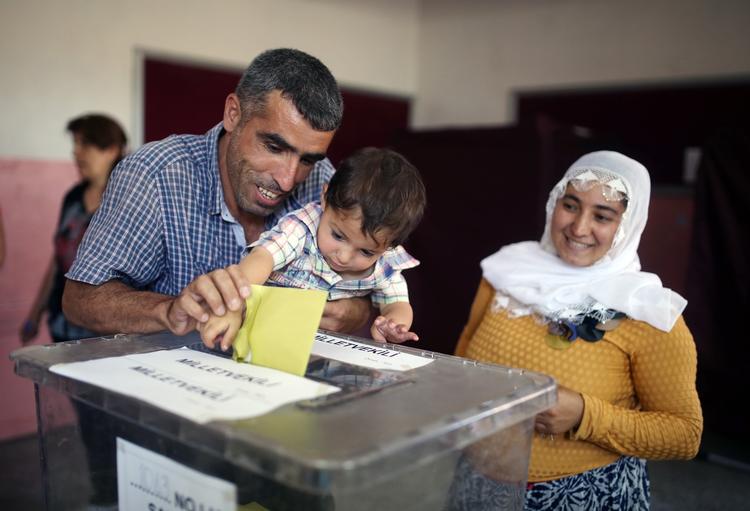 Afstemning. En far får hjælp til at stemme i Diyarbakir i det sydøstlige Tyrkiet, hvor det kurdiske parti HDP har fået omkring 78 procent af stemmerne. 