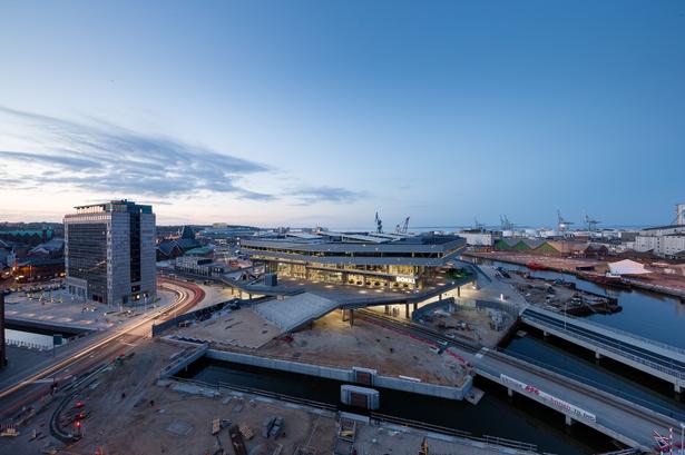 Havnepladsen er endnu ikke færdig. Der går mindst to år, før det omgivende byrum og letbanen er på plads. Havnepladsen strækker sig forbi Hack Kampmanns toldbygning og det andet store nye hus i havnen, ingeniørhøjskolen Navitas. 