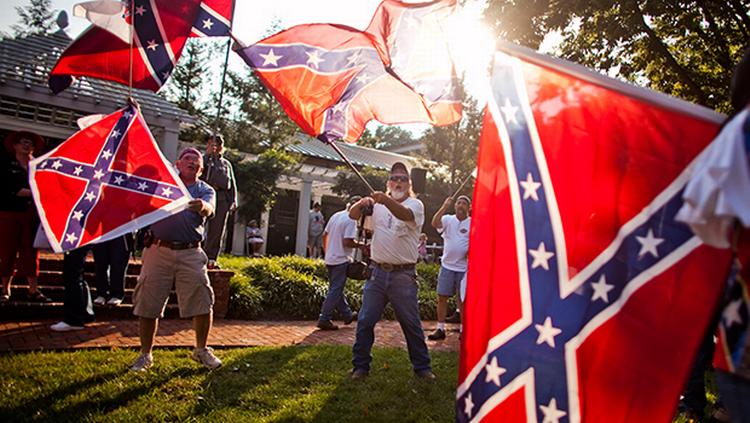 Patriotisme. Medlemmer af en gruppe for sønner af sydstatssoldater flager med de omstridte flag ved en demonstration i Lexington i Virginia. Nu forsvinder sydstatsflaget fra Capitol-grunden i Charleston og fra nummerpladerne i Virginia. 