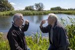 Skål! Byrådsmedlem Asger Møller Madsen (V) (t.v.) og landmand Carsten Søborg (t.h.) skåler i drænvandet fra Carsten Søborgs marker. Målinger fra Aarhus Universitet viser, at det er tre gange renere end kravet til drikkevand. Foto: Søren Schnoor. 
