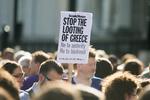 plyndring. Stop plyndringen af Grækenland, står der på dette skilt ved gårsdagens demonstration foran Den Europæiske Centralbanks kontor på Trafalgar Square i London. 