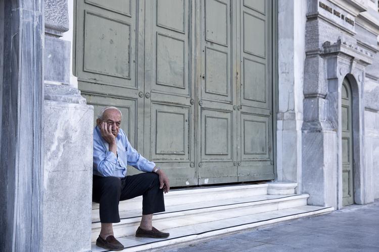 Krise. En græker venter på at modtage sin pension udenfor en offentlig bank i Athen. Men bankerne holder lukket en uge frem, og mange holder vejret ift., hvad der vil ske med landet. 