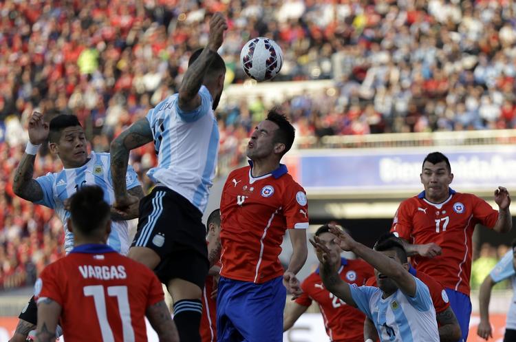Hovedkamp. Argentinas Marcos Rojo  og Nicolas Otamendi  samt Chiles Mauricio Isla i hovedstødsduel i Copa America-finalen. 