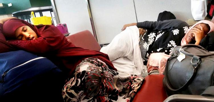 Ventetid. Et par af Eden Issaks landsmænd hviler i lufthavnen, hvor de venter på at de italienske myndigheder tager hånd om dem. Selv ønsker Eden Issak ikke at blive fotograferet. 