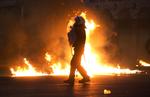 Krise. Politifolk undviger brandbomber kastet af demonstranter her til aften i det centrale Athen, mens parlamentet diskuterer gældsaftale. 