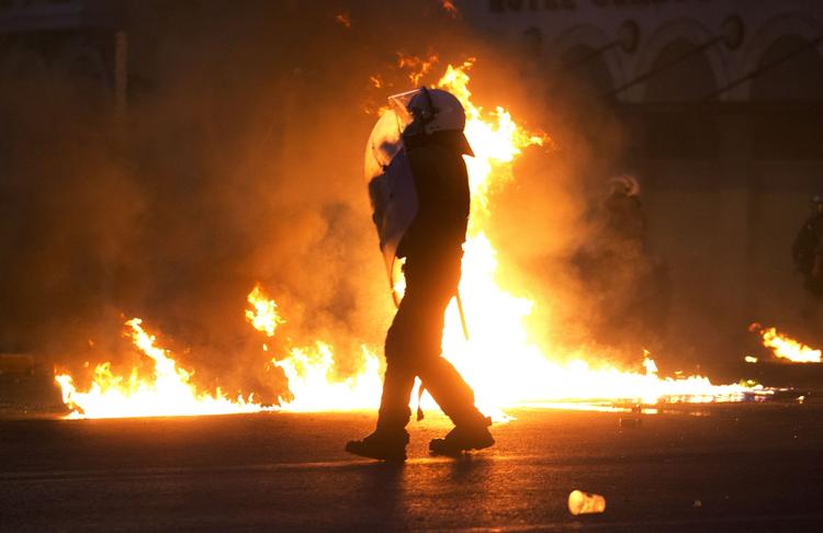 Krise. Politifolk undviger brandbomber kastet af demonstranter her til aften i det centrale Athen, mens parlamentet diskuterer gældsaftale. 