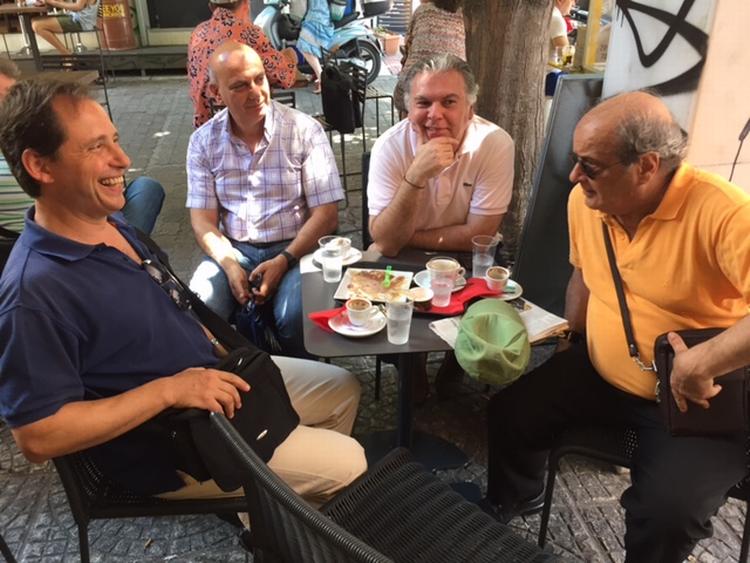 Gældskrise. Elias Fassoulis (i orange trøje) og vennerne sidder på en cafe dagen efter, at parlamentet stemte ja til reformpakke. 