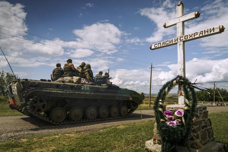 Krigsskueplads. Prorussiske separatister kører forbi et mindesmærke for de 298 personer, der for et år siden blev dræbt da passagerflyet MH17 blev skudt ned over det østlige Ukraine. 