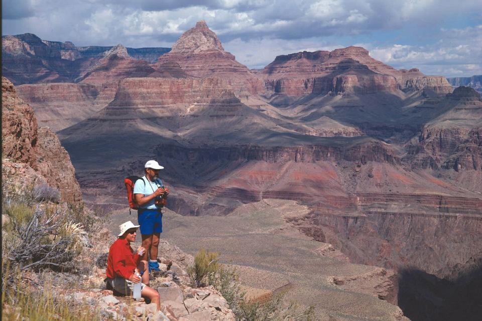 GRAND Canyon i Arizona er dybest set én stor slugt med en rivende flod i bunden. En del personer er styrtet i døden, og de to vandrere på billedet befinder sig faktisk en smule for tæt på kanten. Den yderste del af klippen kan nemlig være porøs. Temperaturerne kan let være på 35 grader og derover. Væskemangel på en vandretur ned og op er derfor en yderligere risiko. 