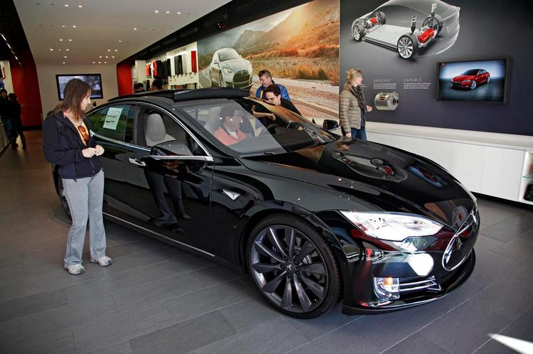 BILSALG. Mulige købere kigger på en Tesla i en af firmaets butikker i Californien. Tesla tænker nye tanker om salgsarbejdet. 