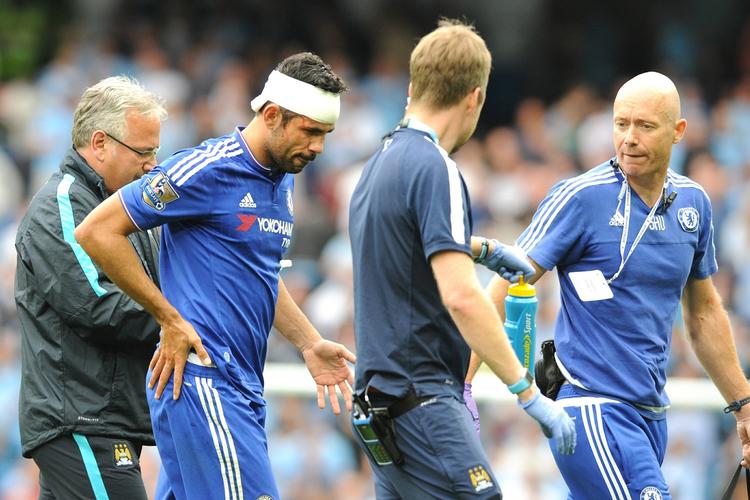 bandage. Chelsea-angriber Diego Costa får hjælp af Manchester Citys lægestab efter en hovedskade i kampen mellem de to klubber søndag. 