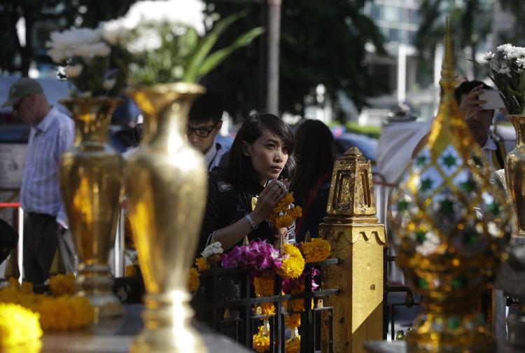Genåbnet. Folk beder, lægger blomster og tænder lys ved Erawan-helligdommen i Bangkok. 