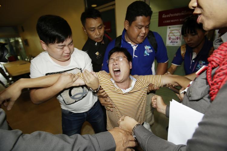 SORG. En mand fra Singapore er opløst i gråd efter at have identificeret sin datter og kone blandt de omkomne efter mandagens bombe i Thailand. 