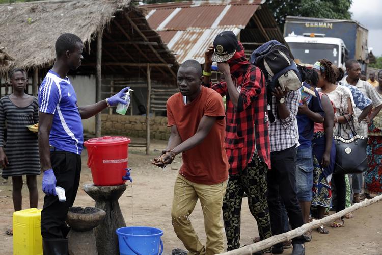 Karantæne. Her ses mænd og kvinder  forlade et karantæne-område for mulige ebolasmittede. De vasker hænder og får tjekket deres temperatur, inden de kan få lov til at gå. 