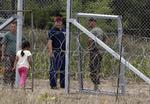 Indenfor. En pige, som er flygtet fra Syrien, går gennem en indgang i pigtrådshegnet på grænsen mellem Serbien og Ungarn. Hun er en blandt tusinder, der søger denne vej i disse dage. 