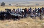 Lokalt. Flere flygtninge skal hjælpes i nærområderne. Her patruljerer tyrkiske soldater ved grænsen mellem Syrien og Tyrkiet, mens syriske flygninge venter på at krydse grænsen. 