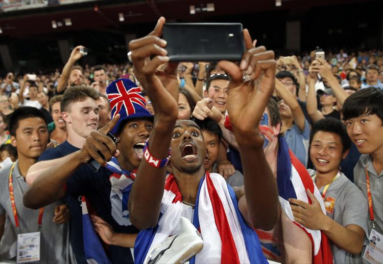 sejrs-selfie. Mo Farah tog glade billeder af sig selv sammen med nogle af de mange fans, da han i dag vandt 5.000-meterløbet ved VM i atletik. Foto: Ng Han Guan/AP 