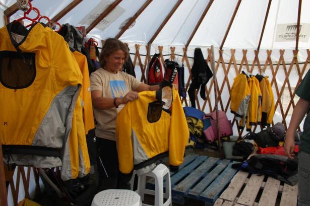 UDSTYR. Kajakinstruktør Andrea Alonso Alfonso finder kajaktøj frem til os i de rigtige størrelser. Tøjet skal forhindre at vi bliver våde, når vi plasker med pagajerne i vandet. 