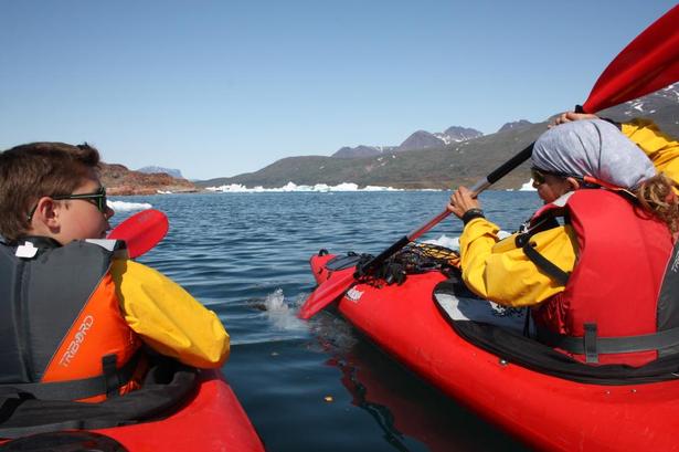 FORKLARING. Instruktøren forklarer, hvordan man skal sætte pagajen i vandet og holde den ene hånd så løst, at pagajen kan dreje en halv omgang rundt, mens man trækker tilbage med den anden hånd. 