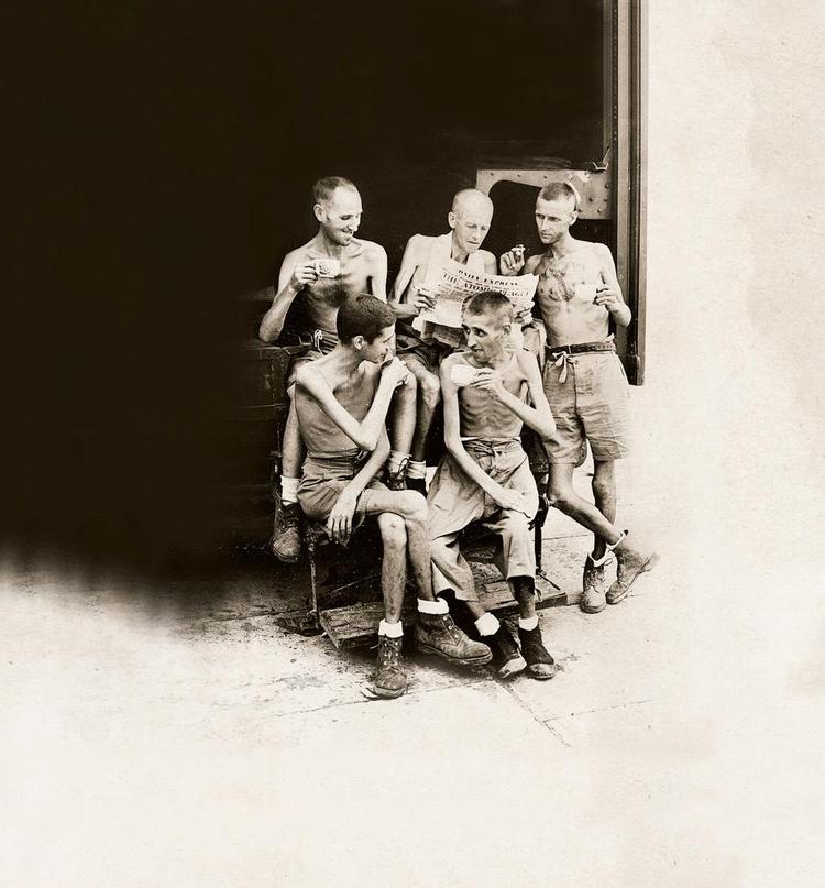 Livet. Udsultede krigsfanger i en japansk lejr i Malaysia læser avis, ryger cigaretter og drikker kaffe, da freden er kommet. Forsidefoto fra bogen: Imperial War Museums 