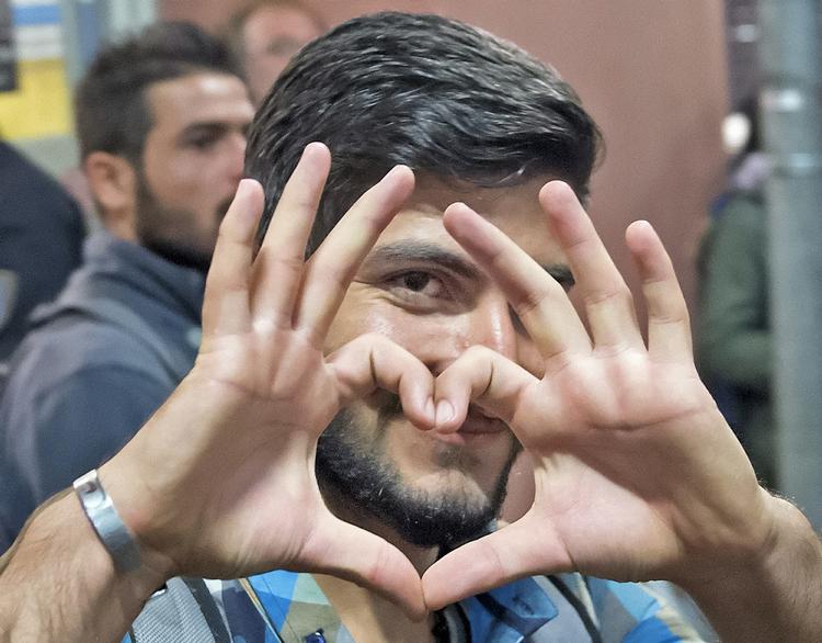 Internationalt. Glade flygtninge og migranter ankommer til München i det sydlige Tyskland. 
