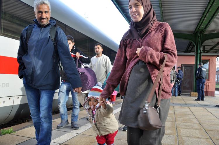 Flygtningekrise. En familie er ankommet med tog  til Eisenhuettenstadt i det østlige Tyskland. 