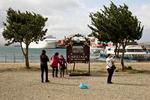 Forblæst. På havnen fotograferer turisterne hinanden foran verdens ende-skiltet, inden de tager på krydstogt til Antarktis. 