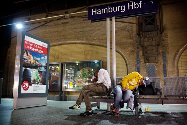 Bænkevarmere. To af de fem fætre, som har rejst sammen i næsten en måned fra Syrien, finder en midlertidig soveplads på en bænk på en perron på hovedbanegården i Hamburg. 