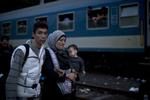 Fordeling. Syriske flygtninge gør klar til at stige på et tog på vej mod Østrig i den ungarnske by Roszke. EU-landene forhandler her til aften om fordeling af de mange flygtninge og migranter. 