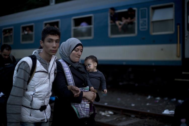 Fordeling. Syriske flygtninge gør klar til at stige på et tog på vej mod Østrig i den ungarnske by Roszke. EU-landene forhandler her til aften om fordeling af de mange flygtninge og migranter. 