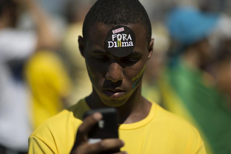 ud! Mange brasilianere demonstrerer mod landets præsident Dilma Rousseff. 'Dilma ud', står der på mærkatet i panden på denne mand, som deltog i en demonstration i sidste måned. 