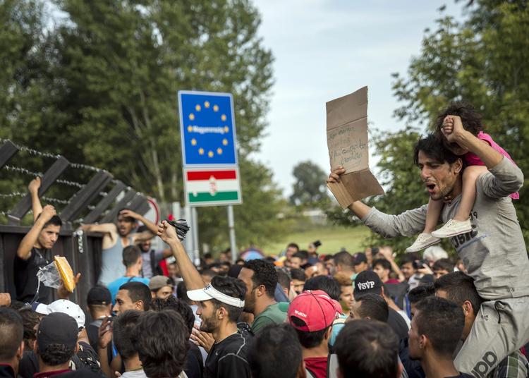 Internationalt. Flygtninge råber op ved den nu lukkede grænse mellem  Serbien og Ungarn. 