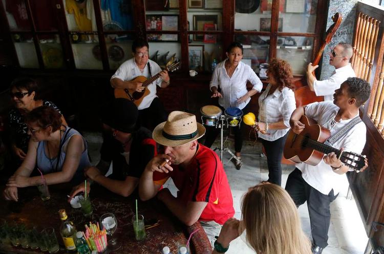 Klimaskifte. Cubanerne er optimistiske efter optøningen af forholdet mellem Cuba og USA, og på forfatteren Ernest Hemingways stambar, Bodeguita del Medio, er stemingen nærmest løssluppen. Foto: Desmond Boylan/AP 