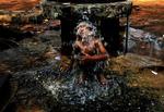 An Indian boy takes bath under a roadside public water supply tap on a hot afternoon in the eastern Indian city of Bhubaneswar, India, Friday, March 27, 2015. Heat wave conditions prevailed as temperature rises in costal parts of eastern India. (AP Photo/Biswaranjan Rout) 
