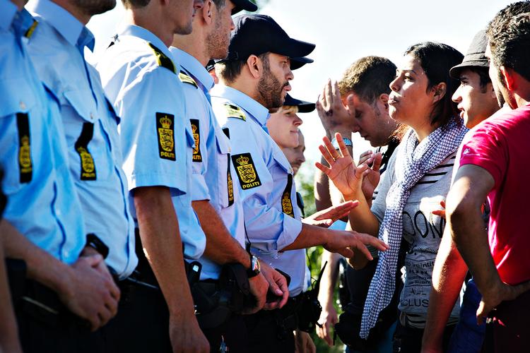 Mens politiet har fat i de to mænd med deres børn, danner politiet en kæde imod  de rasende flygtninge, som vil blande sig. Stemningen er voldsom, men pludselig vender de 300 flygtninge rundt og fortsætter med at gå. 